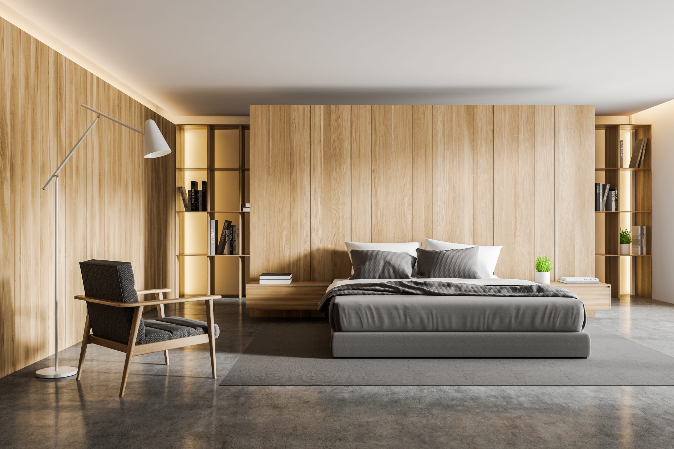 Interior of comfortable master bedroom with wooden walls, concrete floor, king size bed standing on carpet, bookshelves and gray armchair. 3d rendering